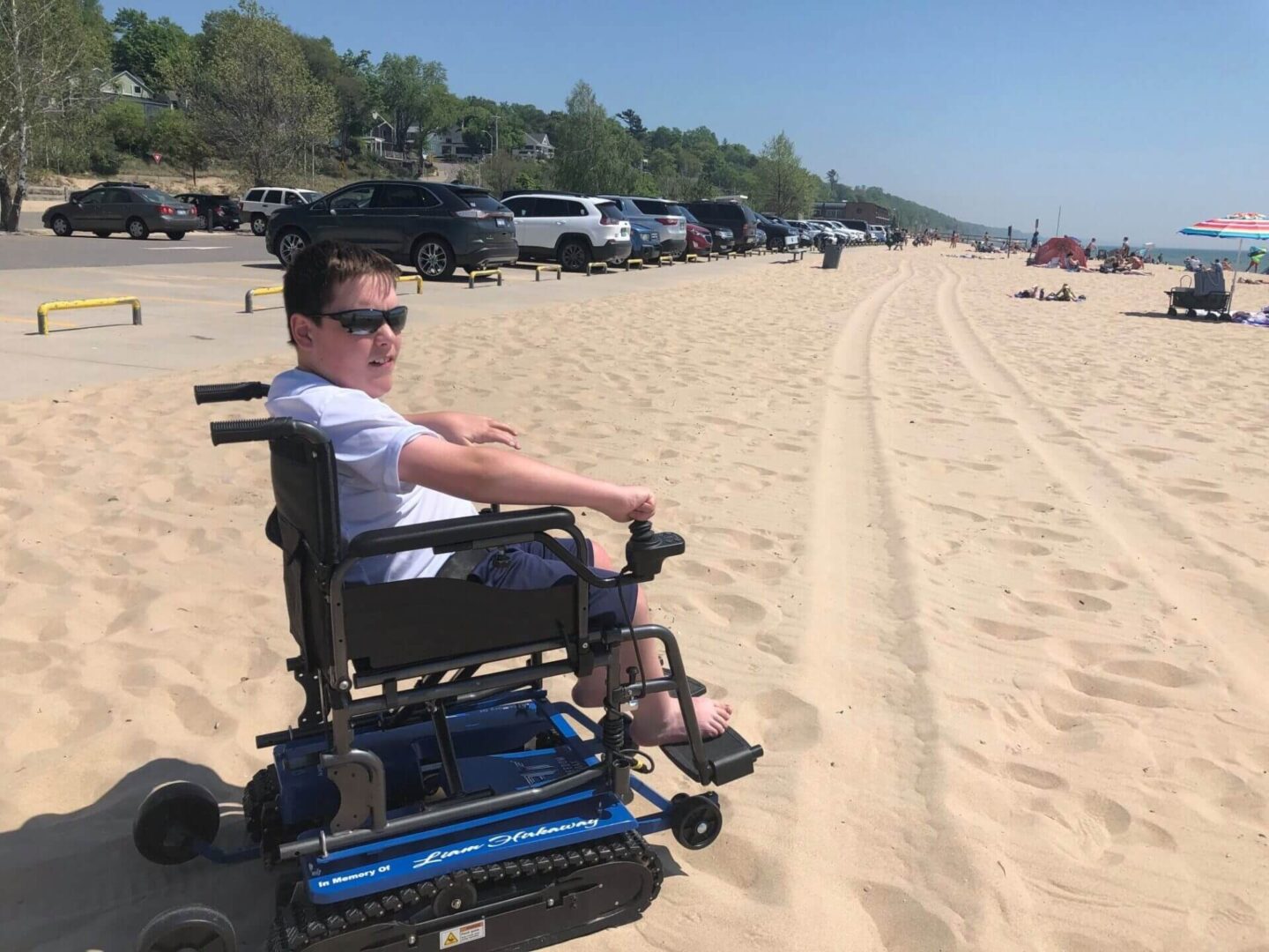 Person in wheelchair enjoying sunny beach day.