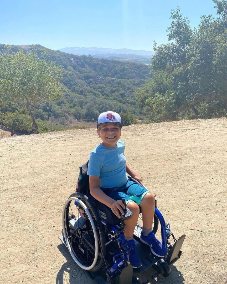 Boy smiling in wheelchair outdoors